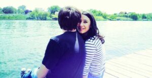 Couple relaxing and destressing at a lake.