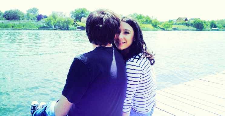 Couple relaxing and destressing at a lake.